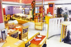 un restaurante con comedor con mesas y sillas en Ashraya International Hotel, en Bangalore