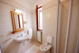 a bathroom with a sink and a toilet and a mirror at Hotel Voce del Mare in Capoliveri
