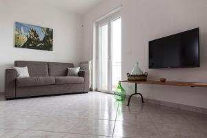a living room with a couch and a flat screen tv at Terrazza Sui Colli in Monopoli