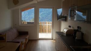 a kitchen with a living room with a couch and a window at Gruberhof in Lagundo