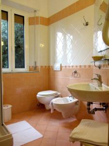 La salle de bains est pourvue de toilettes et d'un lavabo. dans l'établissement Hotel Ausonia, à Follonica