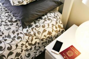 un letto con piumone bianco e nero e un libro di EasySleep - Ostia a Lido di Ostia