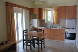 a kitchen with a wooden table and chairs and a kitchen with a sink at Virgin Mary in Rodakino