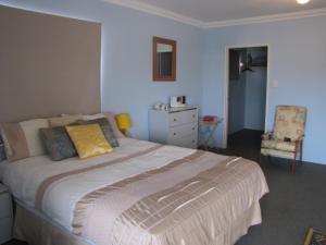 a bedroom with a large bed and a chair at Ocean View Retreat in Jurien Bay