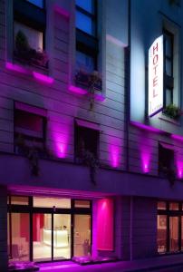 a building with purple lights on the side of it at Le 7 Eiffel Hotel by Malone in Paris