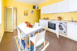 eine Küche mit einem weißen Tisch und weißen Schränken in der Unterkunft Villa Luisa Rooms&Breakfast in Peschiera del Garda