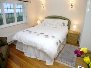 A bed or beds in a room at Pipewell Cottage 