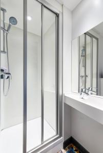een badkamer met een douche, een wastafel en een spiegel bij hotelF1 Evry A6 in Courcouronnes