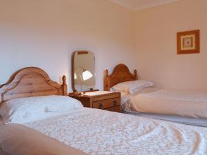 A bed or beds in a room at High Butterbent Cott 