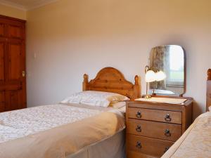 A bed or beds in a room at High Butterbent Cott 