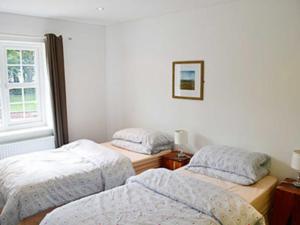 A bed or beds in a room at Tree Tops Cottage 