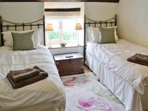 A bed or beds in a room at Hillcroft Cottage 