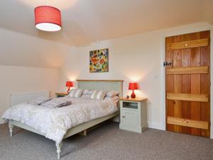 A bed or beds in a room at Honeystring Cottage 