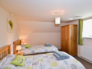 A bed or beds in a room at Honeystring Cottage 
