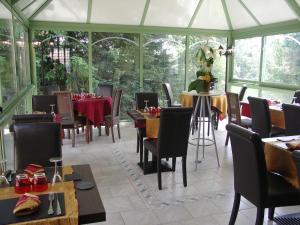 une salle à manger avec des tables et des chaises dans une serre dans l'établissement Relais Saint Louis, Logis, à Bellême