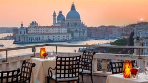 Hotel Danieli, Venice في البندقية: اطلالة على المدينة من شرفة مع طاولات وكراسي