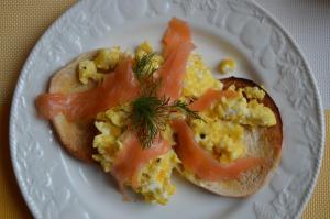 a white plate with a breakfast sandwich with eggs and bacon at Audley Guest House in Llandudno +48 photos