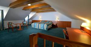 a room with a bed and a table and chairs at Hotel Dvorak in České Budějovice