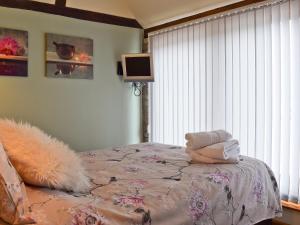 A bed or beds in a room at Plumtree Barn At Gumburn Farm 