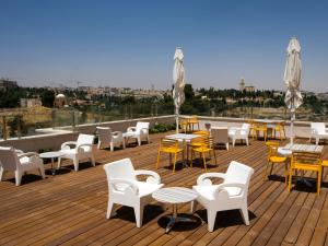 a deck with tables and chairs on a roof at Dan Boutique Hotel Jerusalem in Jerusalem