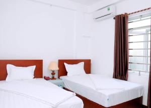 two beds in a room with a window at Sunflower Hotel in Ninh Binh