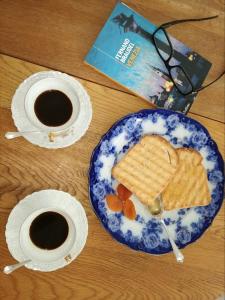 einen Tisch mit einem Teller Brot und zwei Tassen Kaffee in der Unterkunft Via Dei Dori B&B in Mirano