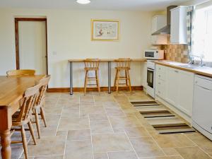 cocina con mesa, sillas y barra en The Wallaces - 28856, en Knarsdale