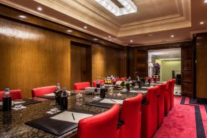 a conference room with a long table and red chairs at Le Casablanca Hotel in Casablanca