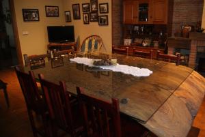 a large wooden table in a living room with chairs at Hotel Rural Casa El Cura in Calzadilla de los Hermanillos