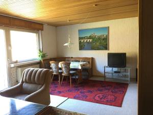 ein Wohnzimmer mit einem Tisch und Stühlen sowie einem TV in der Unterkunft Grosses Ferienhaus im Westerwald in Mengerskirchen