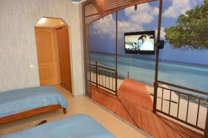 a room with a balcony with a tv and a bed at Private Residence Osobnyak in Odesa