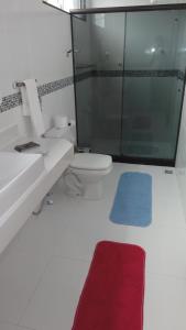 W łazience znajduje się toaleta i przeszklony prysznic. w obiekcie Linda Suíte perto da Praia do Forno w mieście Arraial do Cabo