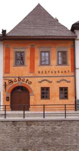 un bâtiment avec un panneau sur son côté dans l'établissement Pension - Restaurant Sabato, à Poprad