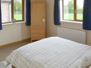A bed or beds in a room at The Stables 