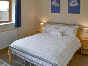 A bed or beds in a room at The Stables 