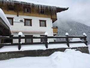 un edificio ricoperto di neve con una recinzione di Mountain Blast a Kirchdorf in Tirol