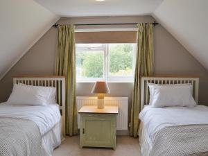 A bed or beds in a room at Pond House Cottage 