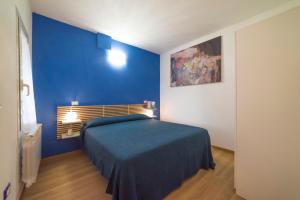 ein blaues Schlafzimmer mit einem Bett und einer blauen Wand in der Unterkunft La Tavernetta in Civezza