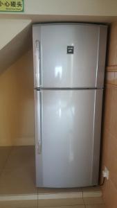 a white refrigerator sitting in a kitchen at Seladah Stay in Kuching