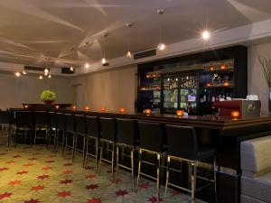 a bar at a restaurant with black chairs at Dan Boutique Hotel Jerusalem in Jerusalem