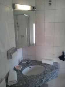 a bathroom with a sink and a mirror at Hotel Restaurant Molitor in Bad Homburg vor der Höhe