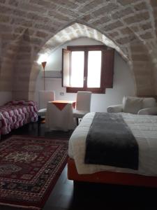 1 dormitorio con 1 cama, mesa y sillas en Bed & Breakfast Idomeneo 63 en Lecce