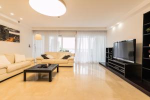 a living room with a couch and a tv at High Class Condo at Marina by FeelHome in Herzliya