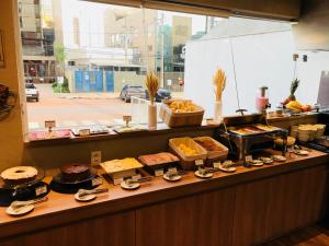 uma linha de buffet com diferentes tipos de sobremesas e bolos em Play Hotel Águas Claras em Taguatinga