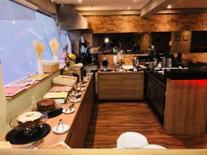 a large kitchen with a long counter with food on it at Play Hotel Águas Claras in Taguatinga