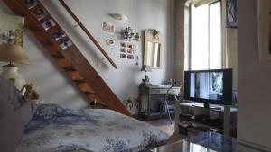 ein Wohnzimmer mit einem Bett und einem TV in der Unterkunft Chez Gene in Avignon