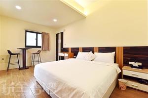sypialnia z dużym białym łóżkiem i stołem w obiekcie Sea Sky Love Homestay w mieście Magong