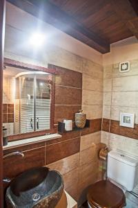 La salle de bains est pourvue d'un lavabo, de toilettes et d'un miroir. dans l'établissement Ihnilatis, à Kerkíni