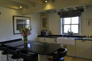 a kitchen with a table and chairs and a sink at Birkend Farmhouse in Feetham