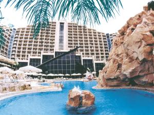 un complexe avec une piscine et un grand bâtiment dans l'établissement Dan Eilat Hotel, à Eilat